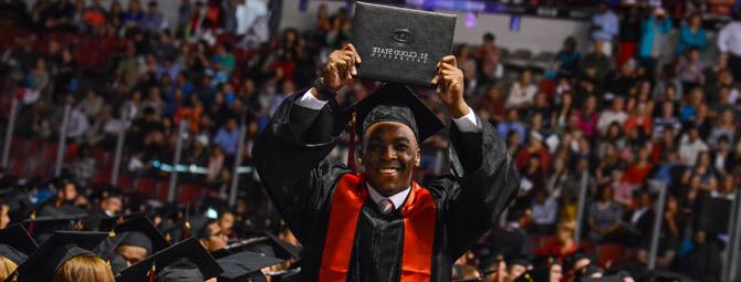 a student at graduation holding his diploma