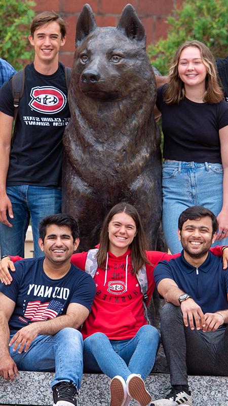 Students around husky statue