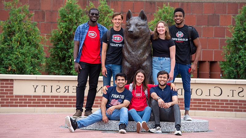 Group of students by husky statue